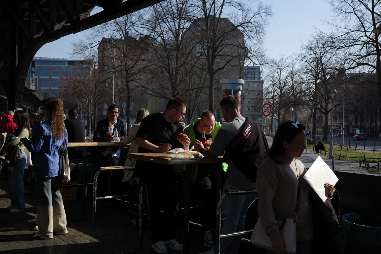 Classic Burgermeister spot also being illuminated by beautiful sunlight as people gather and eat together.